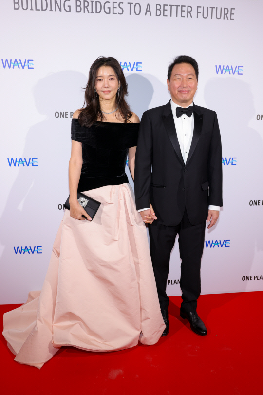 지난 14일(현지시간) 프랑스 파리에서 열린 갈라 디너에 참석한 최태원(오른쪽) 회장과 김희영 티앤씨(T&C) 재단 이사장이 다정하게 손을 잡고 미소를 짓고 있다.  [게티이미지코리아]